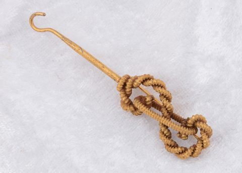 A 14k marked knot button hook brooch