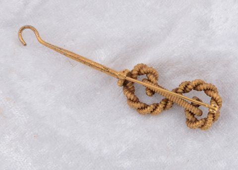 A 14k marked knot button hook brooch