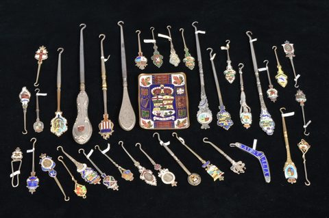 A collection of coloured enamel terminal souvenir button hooks and loops