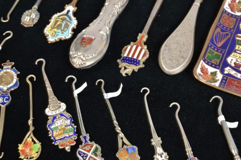 A collection of coloured enamel terminal souvenir button hooks and loops
