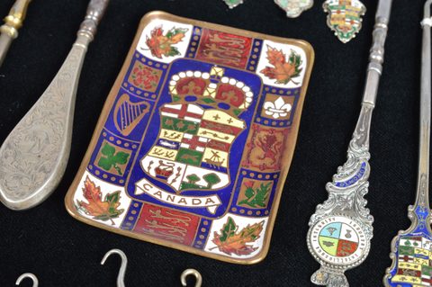 A collection of coloured enamel terminal souvenir button hooks and loops