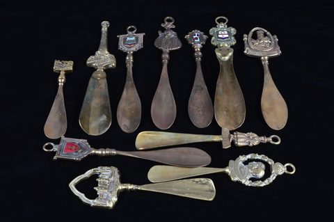 A collection of eleven brass souvenir shoehorns