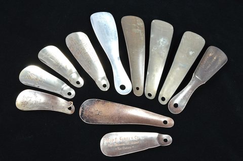 A collection of eleven steel shoehorns