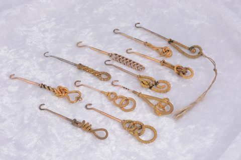 A collection of eleven textured knot design gilt metal button hooks