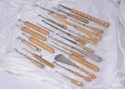 A collection of gold and silver handled button hooks