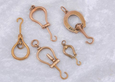 A collection of miniature folding horseshoe shaped button hooks