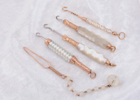 A collection of mother of pearl and gilt metal button hooks
