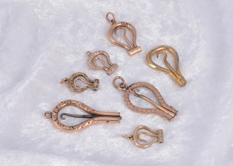 A collection of seven folding button hooks