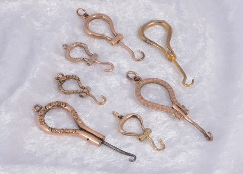 A collection of seven folding button hooks