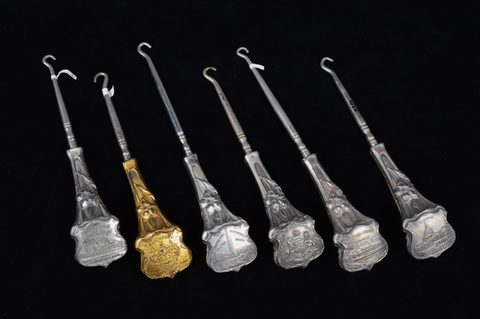 A collection of souvenir button hooks