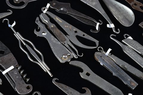 A collection of stainless stell advertising multi tools containing button hooks