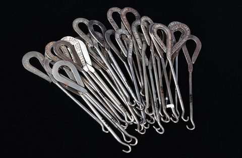 A collection of steel advertising button hooks