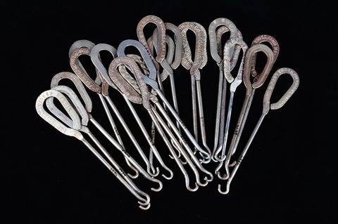 A collection of steel advertising button hooks
