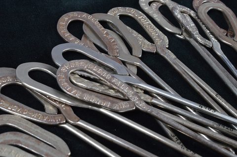A collection of steel advertising button hooks