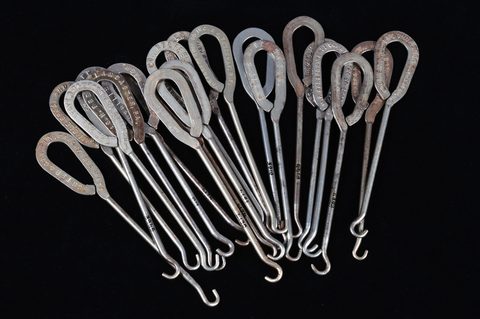 A collection of steel advertising button hooks
