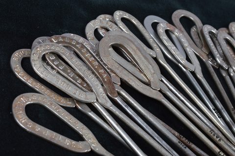 A collection of steel advertising button hooks