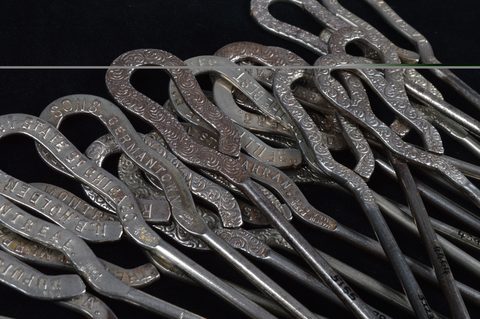 A collection of steel advertising button hooks