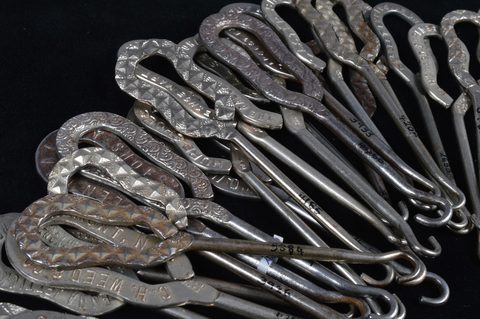 A collection of steel advertising button hooks