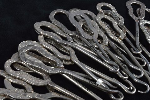 A collection of steel advertising button hooks