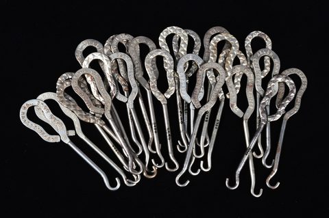 A collection of steel advertising button hooks