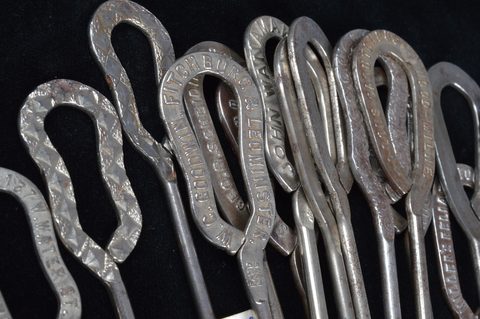 A collection of steel advertising button hooks