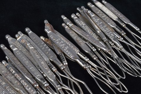 A collection of steel advertising glove button loops