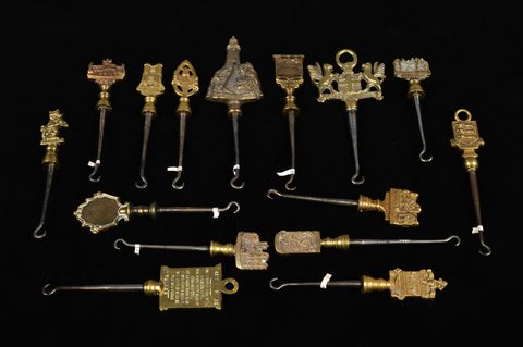 A collection of steel brass handle mounted souvenir and commemorative button hooks