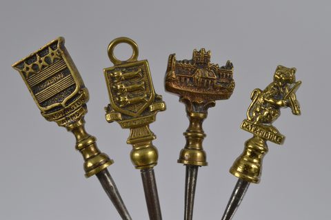 A collection of steel brass handle mounted souvenir and commemorative button hooks