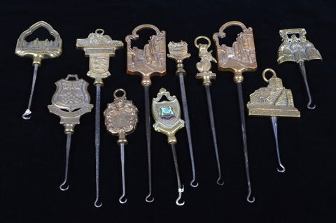 A collection of steel brass handle mounted souvenir and commemorative button hooks
