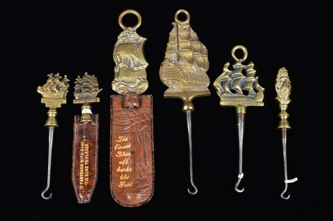 A collection of steel brass handle mounted souvenir and commemorative button hooks