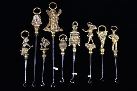 A collection of steel brass handle mounted souvenir and commemorative button hooks