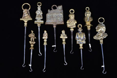 A collection of steel brass handle mounted souvenir and commemorative button hooks