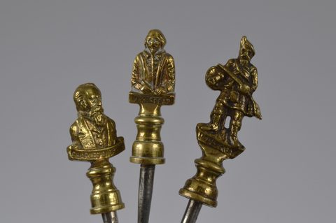 A collection of steel brass handle mounted souvenir and commemorative button hooks