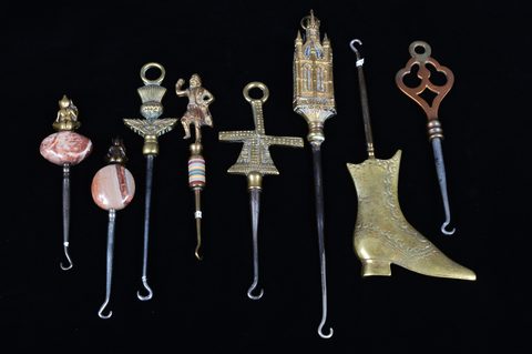 A collection of steel brass handle mounted souvenir and commemorative button hooks