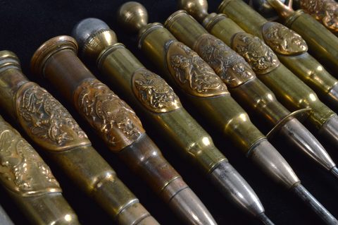 A collection of thirteen trench art Royal Engineers 'Honi soit qui mal y pense' cypher mounted converted shell button hooks