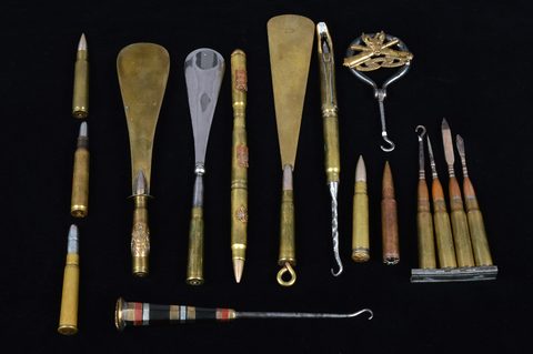A collection of trench art converted shell button hooks and accessories