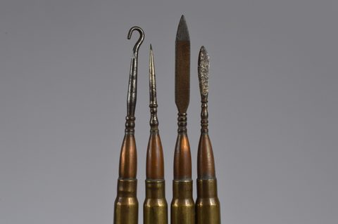 A collection of trench art converted shell button hooks and accessories