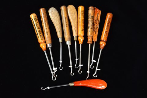 A collection of turned and carved wooden handled button hooks