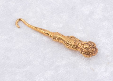 A Victorian 9ct gold floral embossed button hook