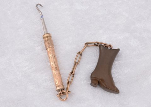 A Victorian vulcanite and gold plated lapel novelty button hook