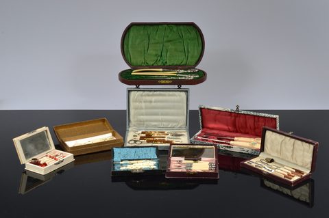 Eight cased Victorian and later bone and resin dressing table sets