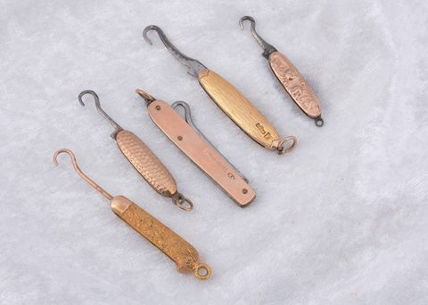 Five 9ct gold and yellow metal folding button hooks