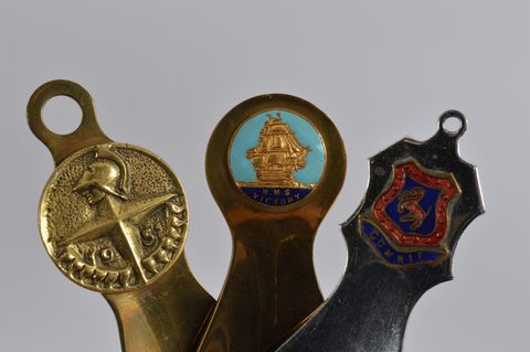 Five brass and one steel commemorative or souvenir shoehorns