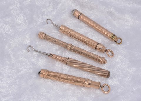 Five gilt metal protracting button hooks