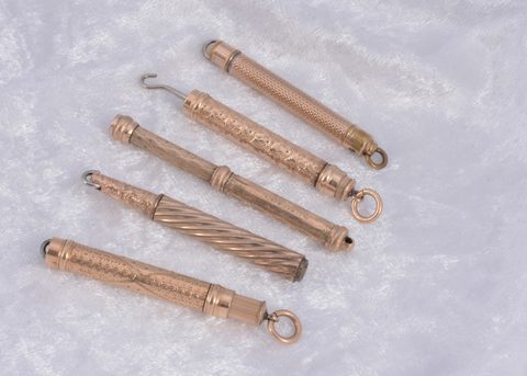Five gilt metal protracting button hooks