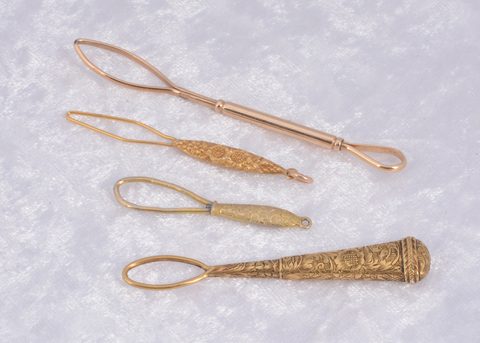 Four gilt metal button loops