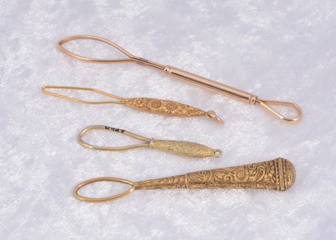 Four gilt metal button loops