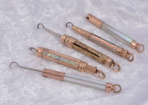 Four mother of pearl protracting gilt metal Victorian button hooks