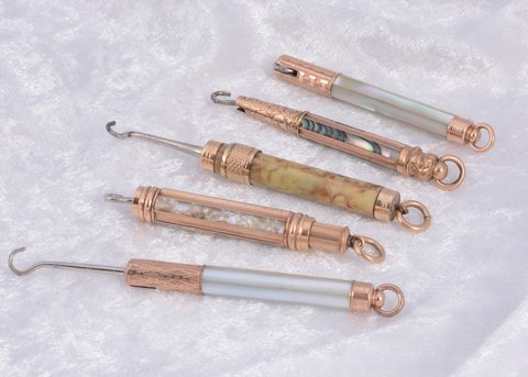 Four mother of pearl protracting gilt metal Victorian button hooks