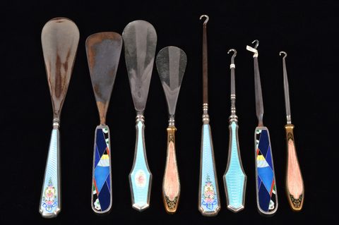 Four sets of matching enamel handled shoehorn and button hooks